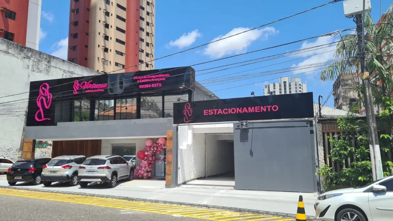Fachada da Virtuosa Belém com o letreiro rosa e a entrada do estacionamento