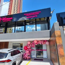 Porta da Virtuosa Belém decorada com balões rosa, sob o letreiro em neon